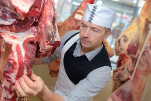 Butcher examining the quality of meat before it makes its way to shelves