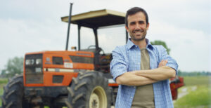 Male farmer standing into of a tractor